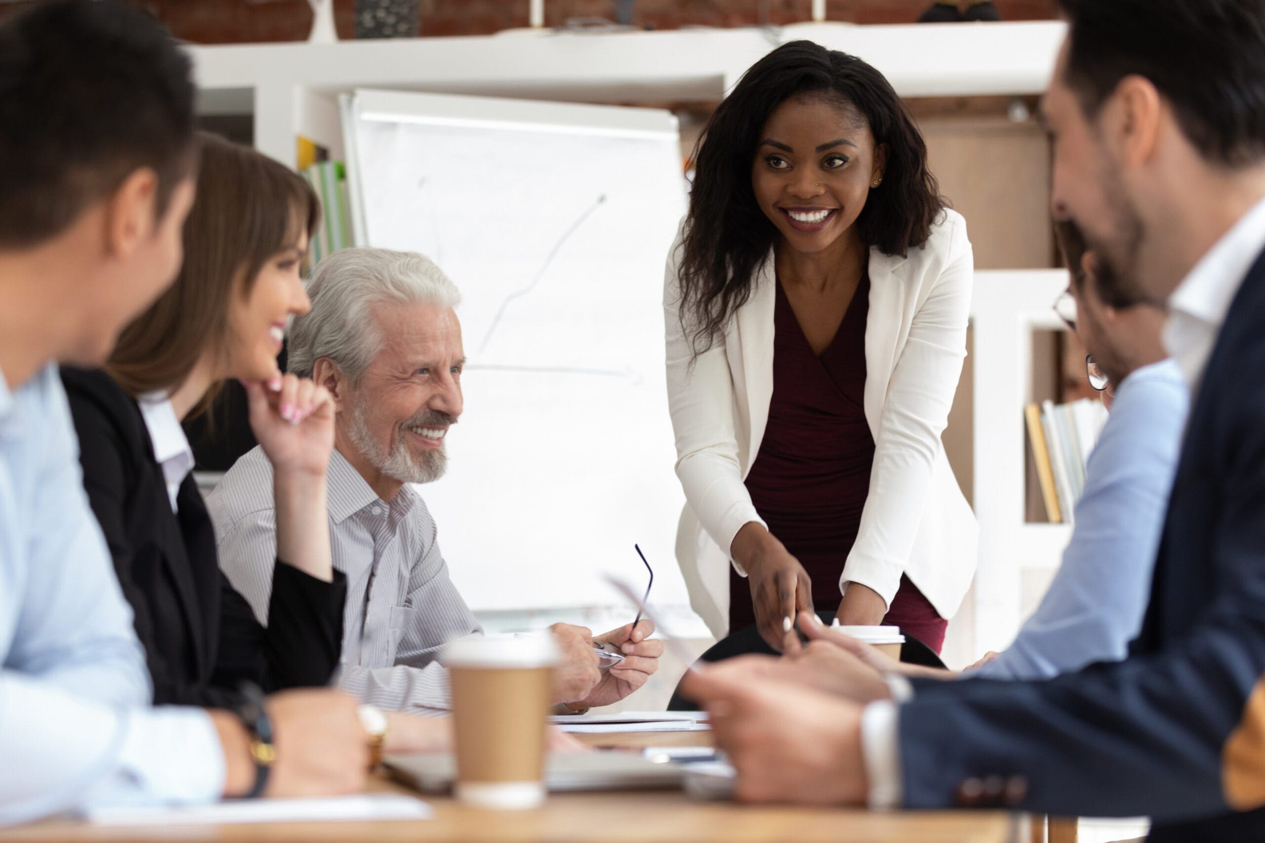 Diverse businesspeople gathered together for negotiations lead by african businesswoman stock photo